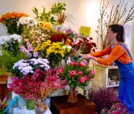 Elissa at Larkspur Florist adds the finishing touches to a display of Mothers Day Bouquets. (Photo: Julie Higgs)